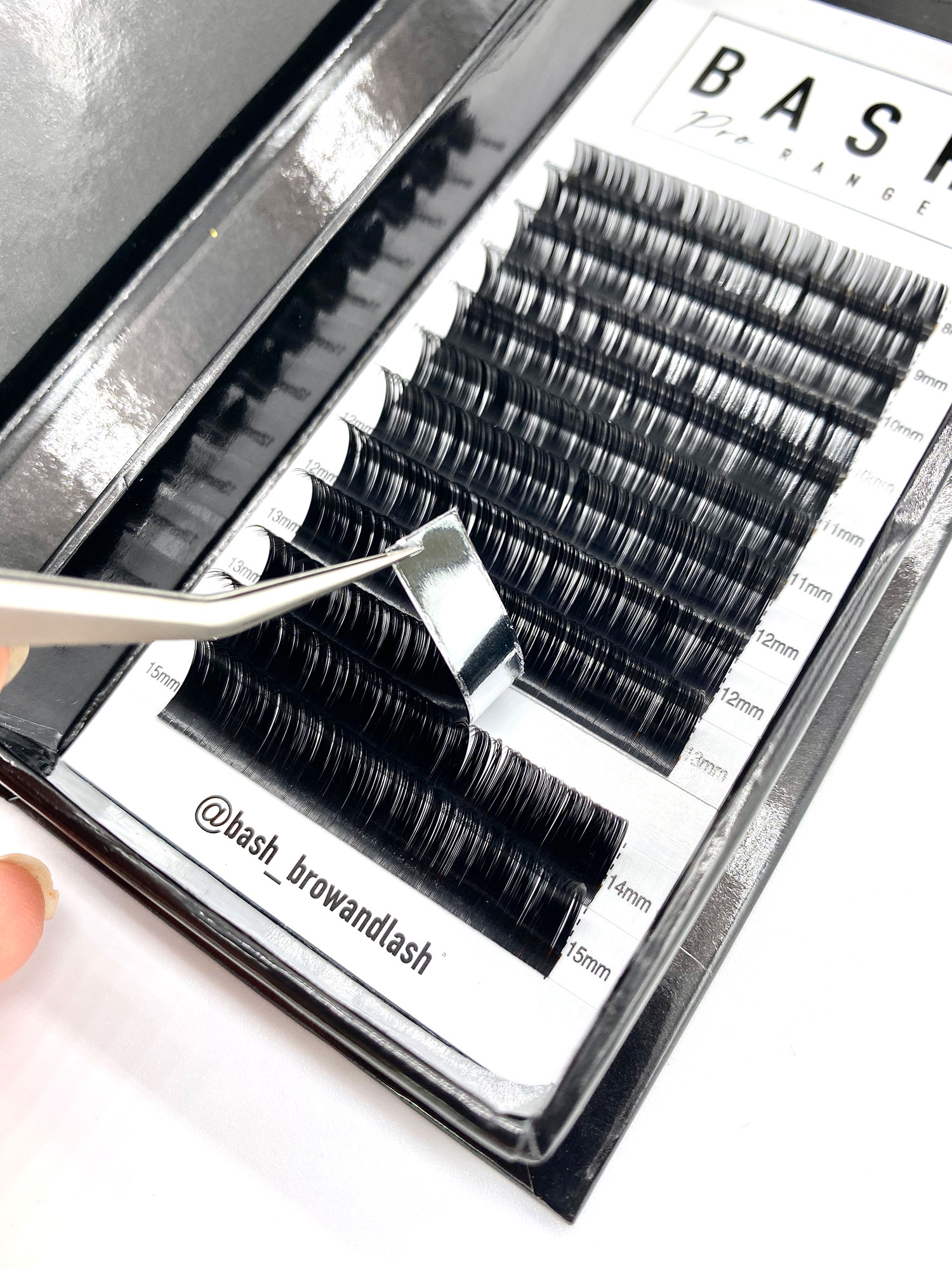 box with Russian volume lashes being picked up with tweezers