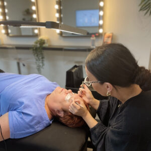 Student working on a model during a russian volume lash extension course.